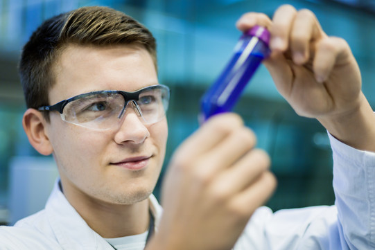 A researcher holds a sample vessel in his hand.